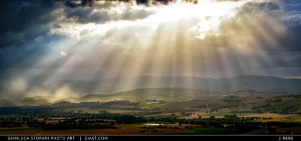 Paesaggio della Valle del Potenza con i raggi del sole che filtrano tra le nuvole grigie